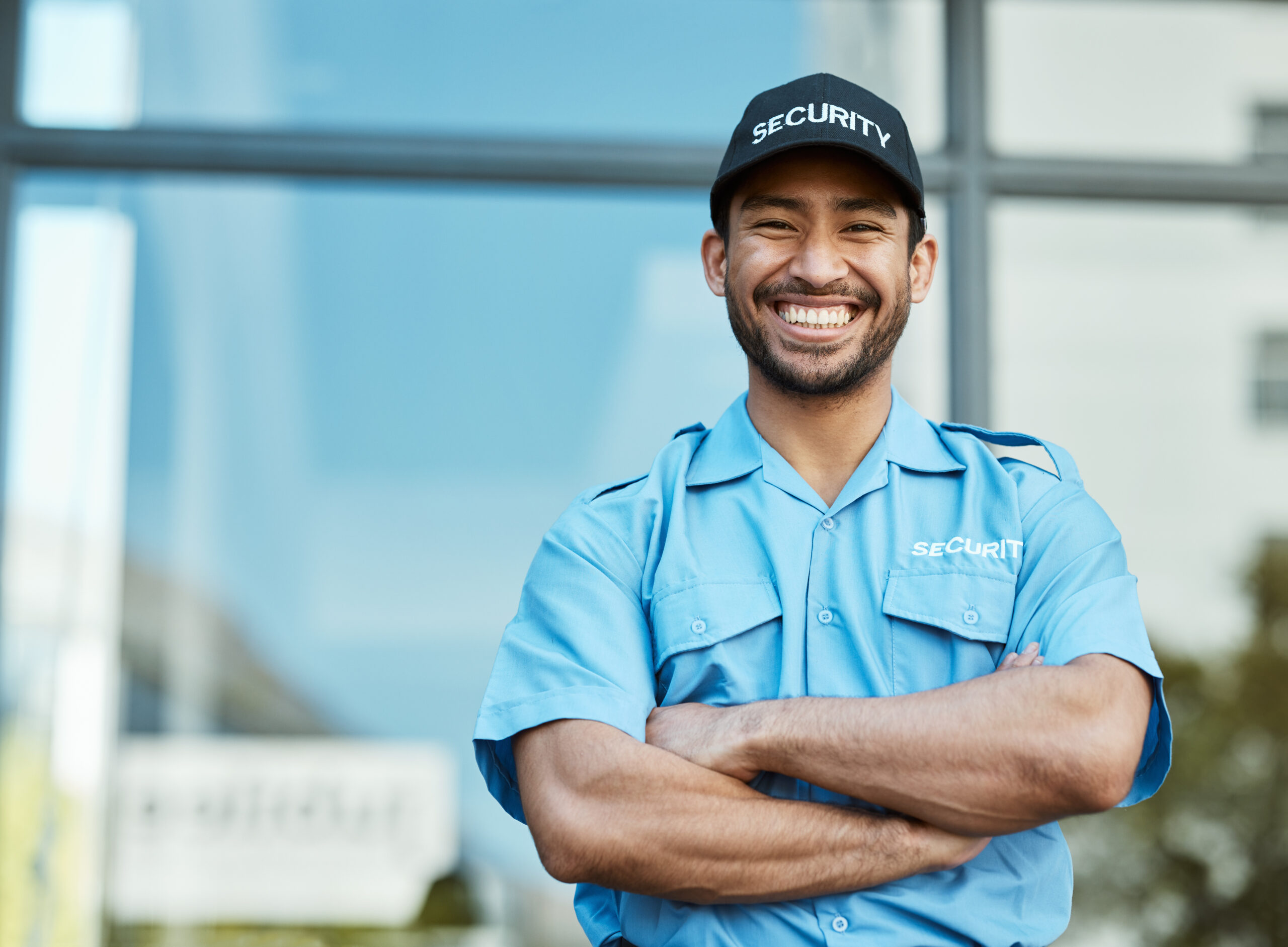 Happy man, portrait and security guard with arms crossed in city for career safety or outdoor protection. Male person, police or officer smile in confidence, law enforcement or patrol in urban town Happy man, portrait and security guard with arms crossed in city for career safety or outdoor protection. Male person, police or officer smile in confidence, law enforcement or patrol in urban town.